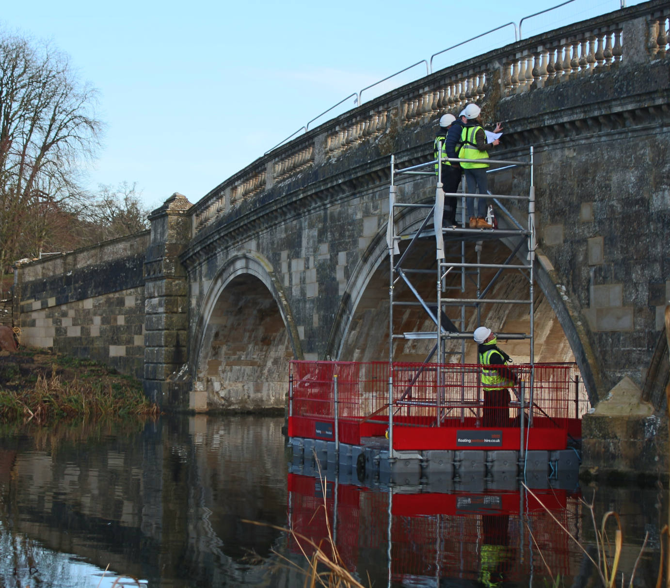 Floating Pontoon Hire modular pontoon platform providing safe access for bridge inspection and structural works beneath a historic stone arch bridge