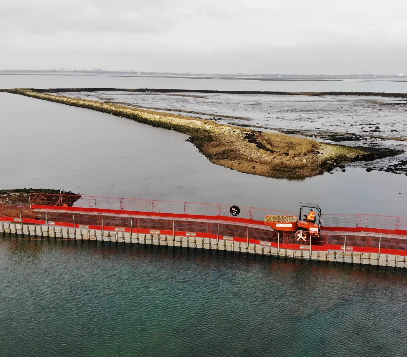 Wheeled site dumper operating on a modular floating pontoon causeway providing temporary access across a tidal estuary